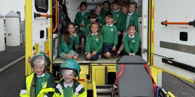 Children posing at the back of an ambulance