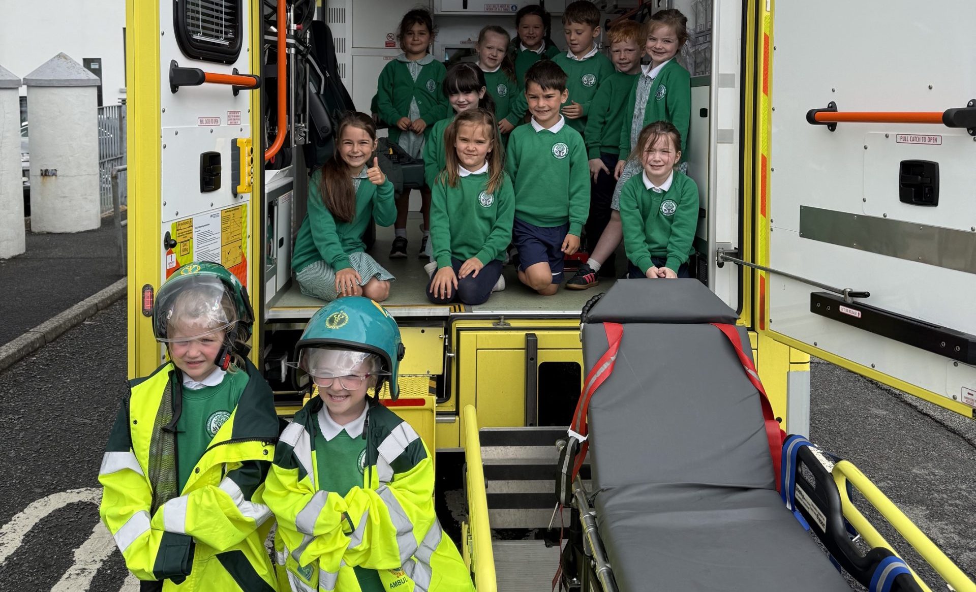 Children posing at the back of an ambulance